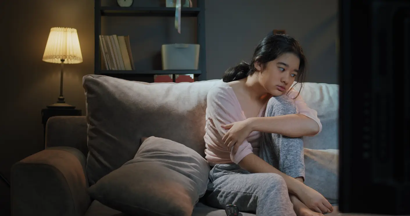 tourette 3 girl sitting on sofa bored